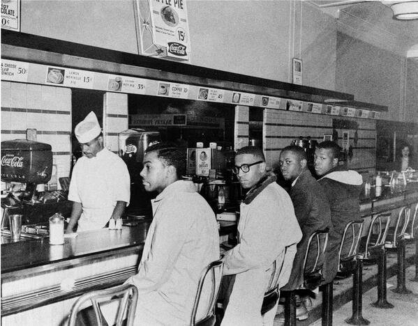 4 studenti siedono in posti designati per i bianchi. Greensboro NC, 1960