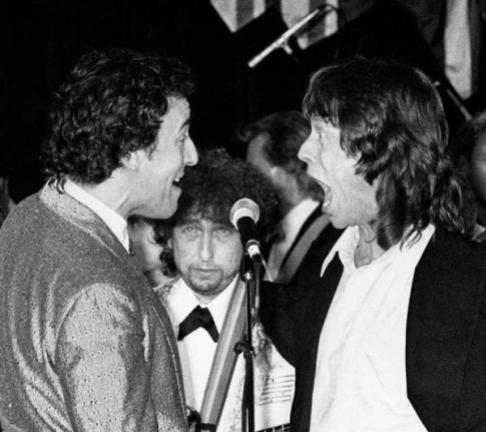 Bob Dylan guarda Bruce Springsteen e Mick Jagger alla cerimonia di induzione del Rock and Roll Hall of Fame, 1988