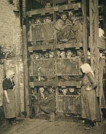 Minatori stipati in un ascensore di una miniera di carbone dopo una giornata di lavoro