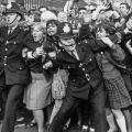 La polizia che lotta per frenare i fan dei Beatles fuori da Buckingham Palace nell’ottobre del 1965