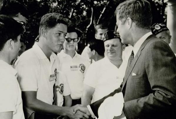Un adolescente Bill Clinton che stringe la mano a John Kennedy