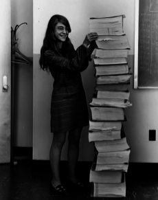 Margaret Hamilton, ingegnere del software principale del Progetto Apollo, si trova accanto al codice che ha scritto a mano e che è stato utilizzato per portare l'umanità sulla luna. [1969]