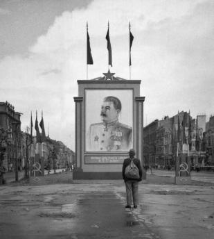 Un civile tedesco guarda un manifesto di Stalin posto di recente sulla Unter-den-Linden di Berlino 1945