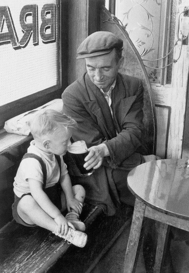 Un uomo che condivide una pinta con suo figlio in un pub irlandese, anni '50