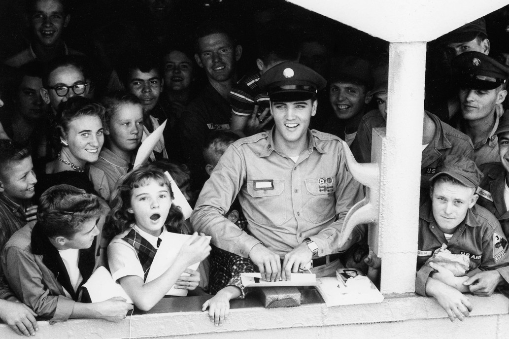 Elvis sorride e lancia baci ai fan mentre il Generale Randall si allontana dal molo nel 1958. Fotografia di Bill Ray